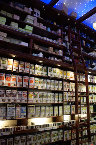 Artisan tins of gourmet tisanas arranged on a rustic wooden shelf with soft natural light.