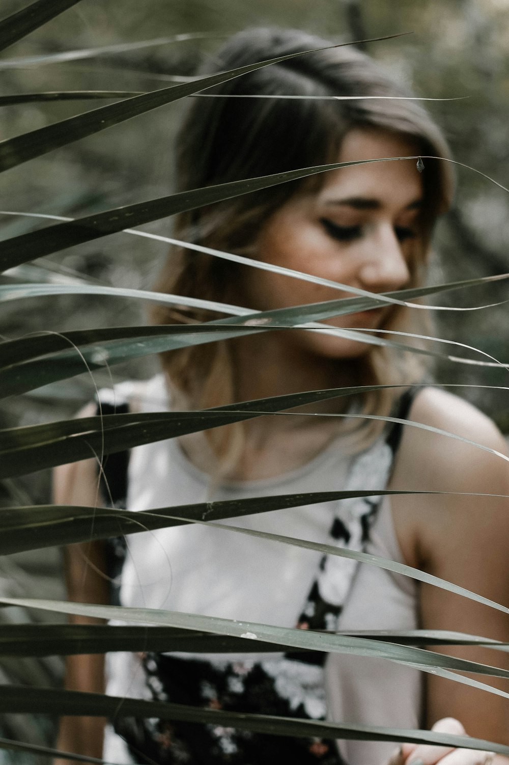 woman standing near linear leafed plant