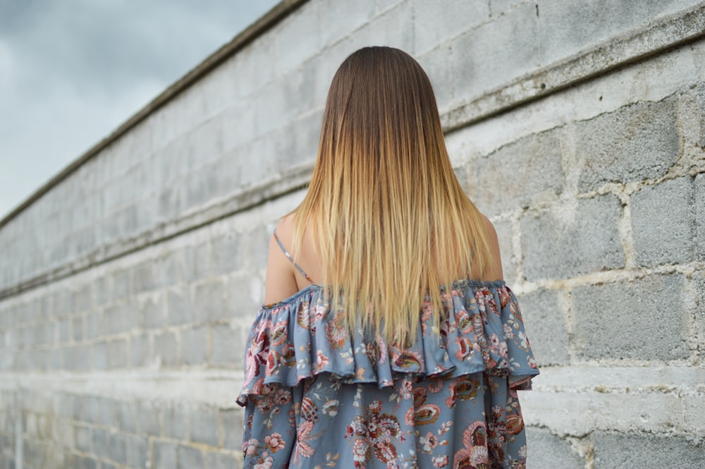 woman standing near white and gray wall during daytime