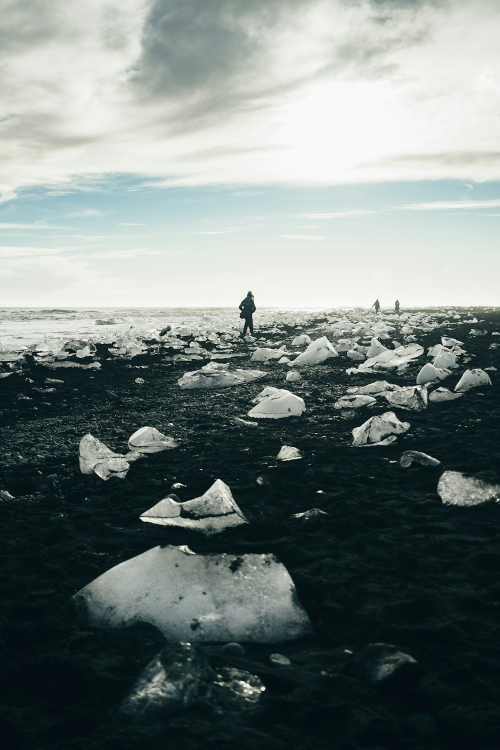 person walking beside body of water during daytime