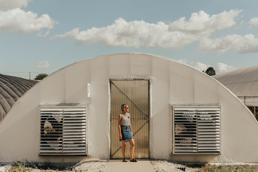 girl in gray tank top behind white shed