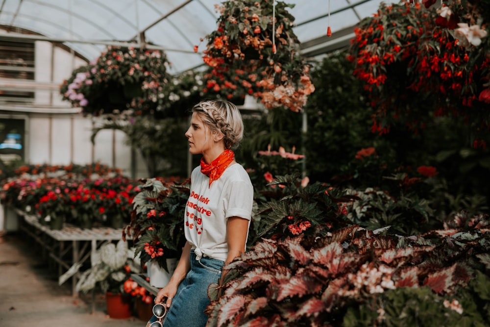 woman in red and white t-shirt standing near flowers