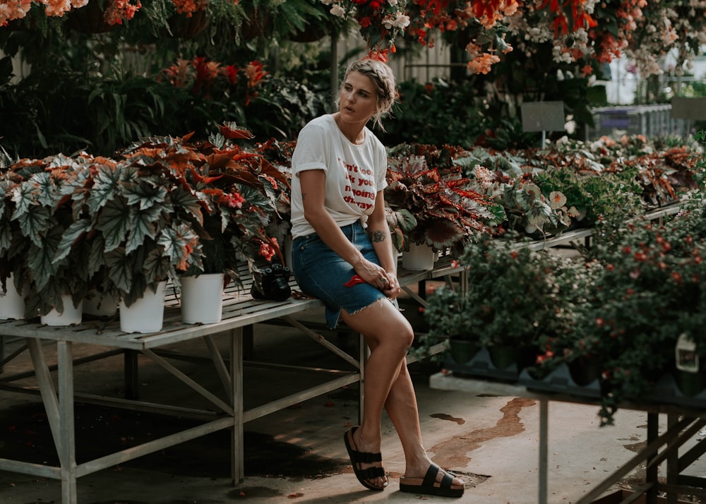 woman leaning against plant holder stand
