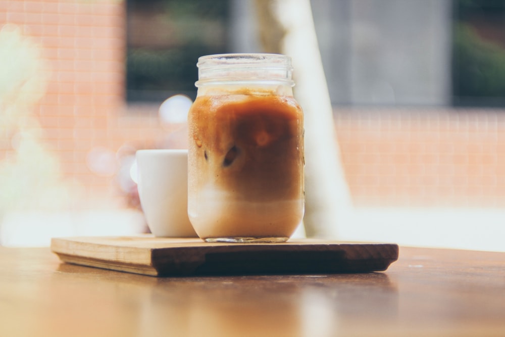 clear glass jar on brown wooden coaster on table