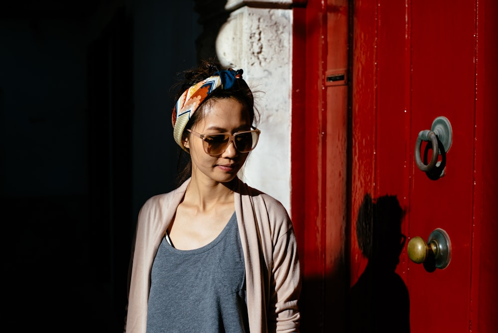 Femme en cardigan gris debout près de la porte en bois