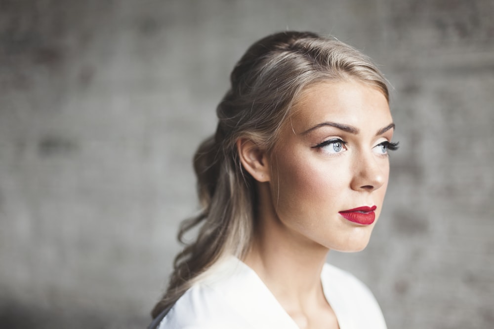 donna che indossa camicia bianca con rossetto rosso