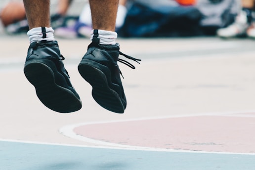 A close-up of an athlete's legs in motion, captured with motion-tracking technology against a blurred sports field background.