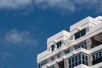 A bright, modern school building with blue and white accents under a clear sky.