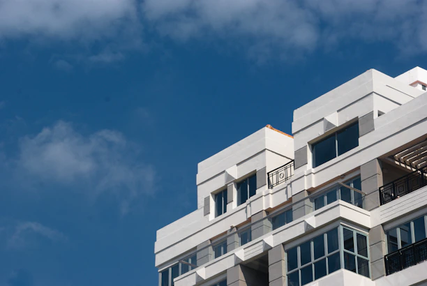A modern university building with blue and white colors under a clear sky.