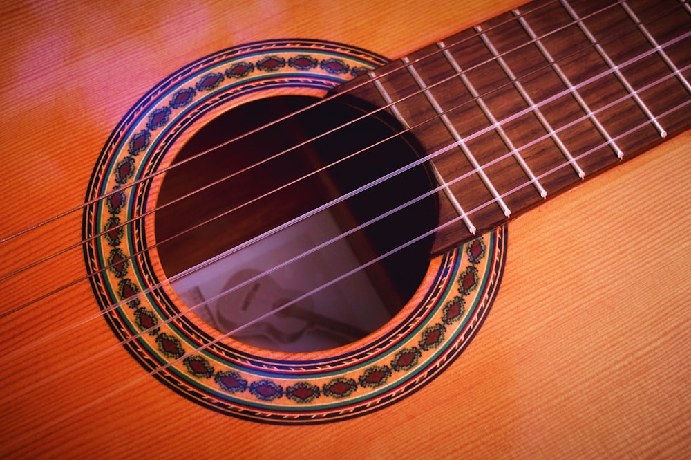 closeup photography of brown acoustic guitar