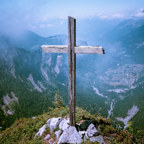 photo of brown wooden cross at cliff