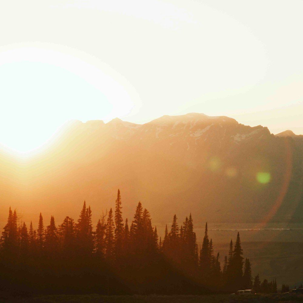 the sun is setting over a mountain range