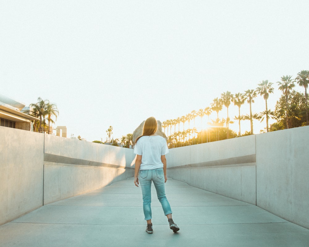 a woman riding a skateboard down a cement walkway