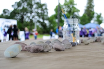 Children and families gathered around a lapidary demonstration, watching stones being shaped and polished.