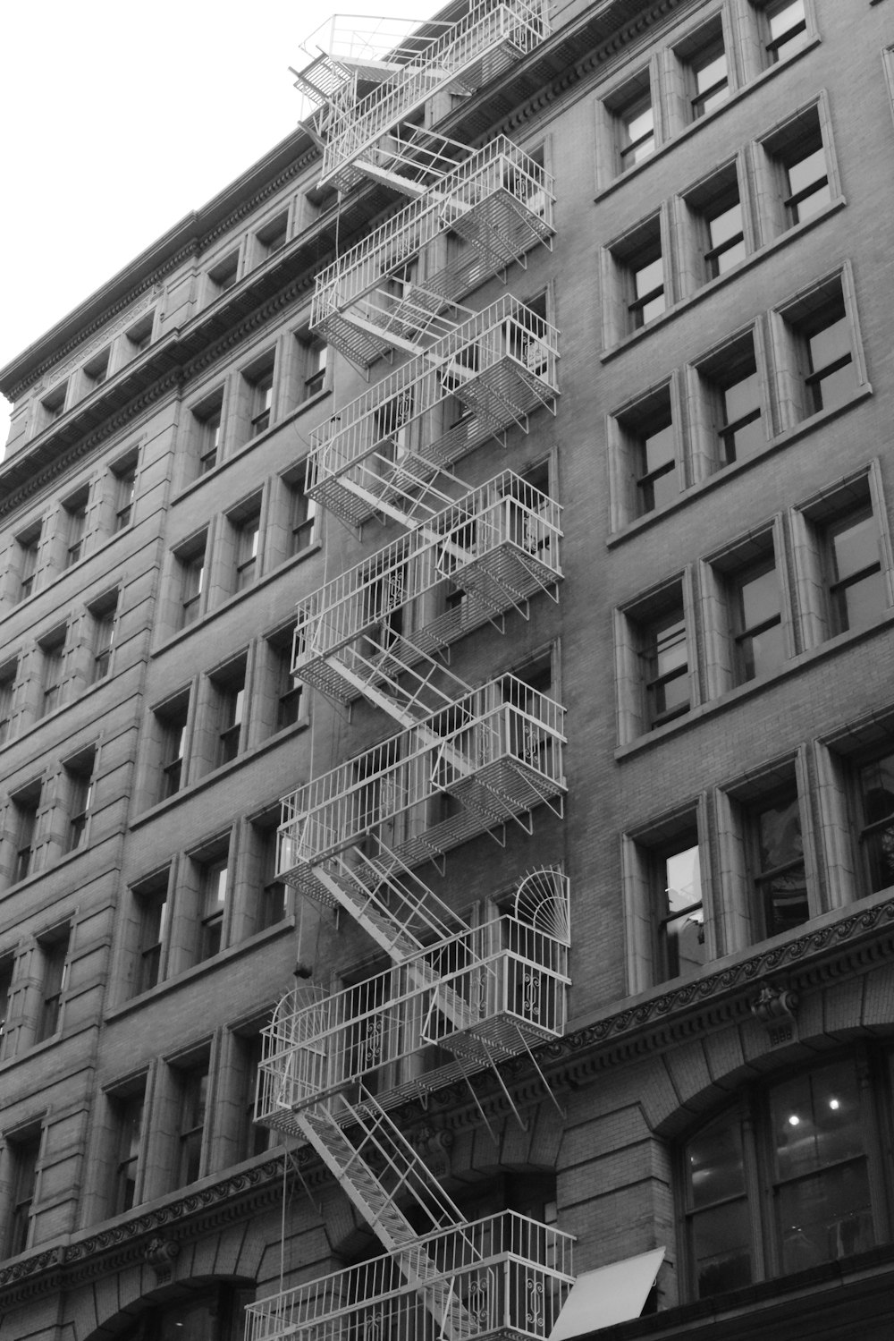 grayscale photo of building with side stairs