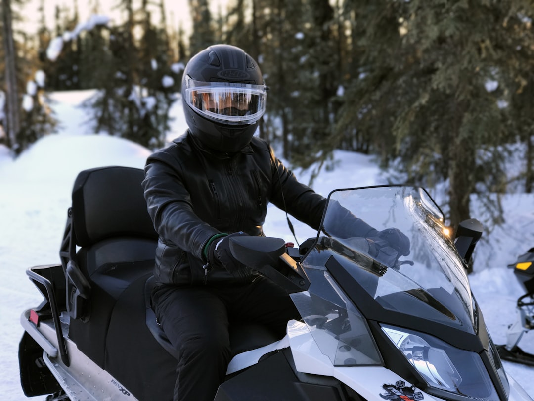 person riding on snowmobile, snowmobile rider