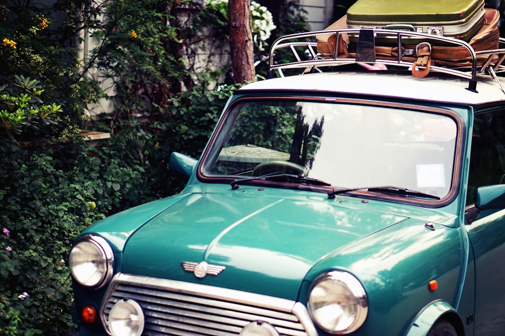 Mini Morris verde clássico estacionado perto do mato durante o dia