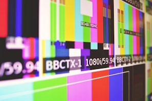 A series of multicolored horizontal and vertical bars are displayed, reminiscent of a television test pattern. Various colors such as green, blue, pink, and yellow are present along with white text containing alphanumeric codes.