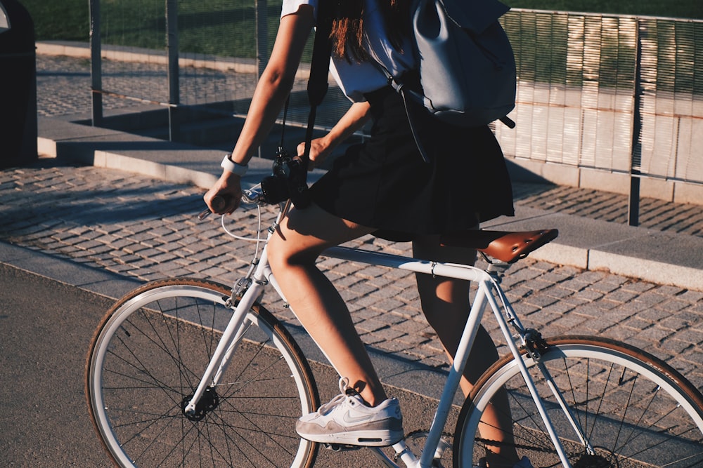 donna in sella a una bici rigida bianca