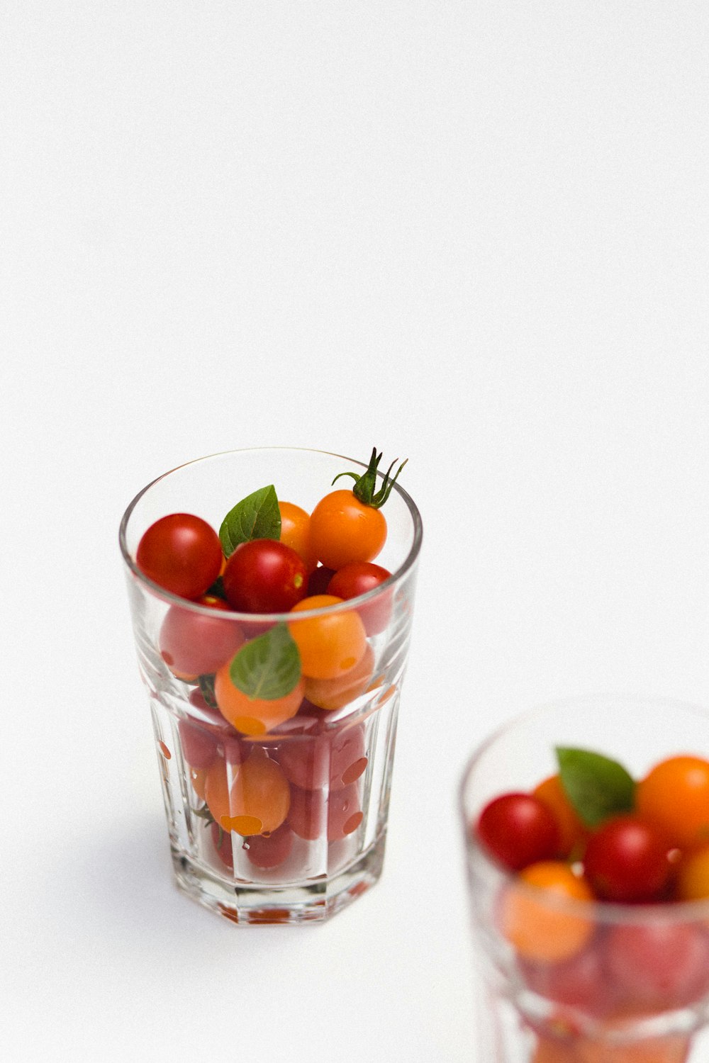 red and orange fruits in clear rock glass