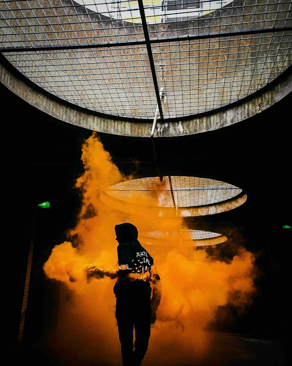 silhouette of person surrounded by orange smoke on underground