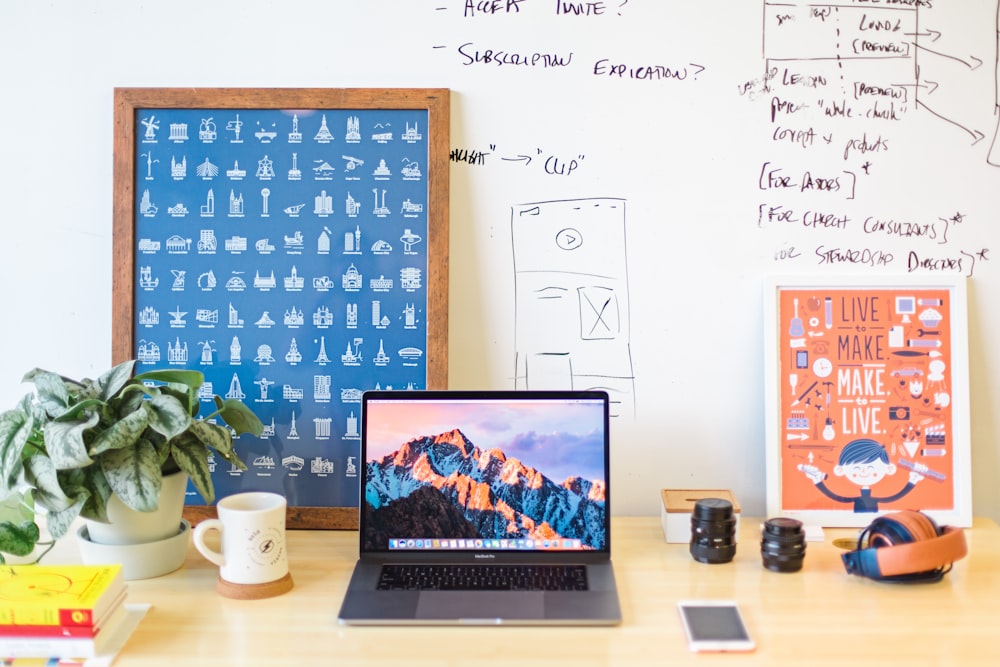 MacBook Pro on brown wooden table beside white mug