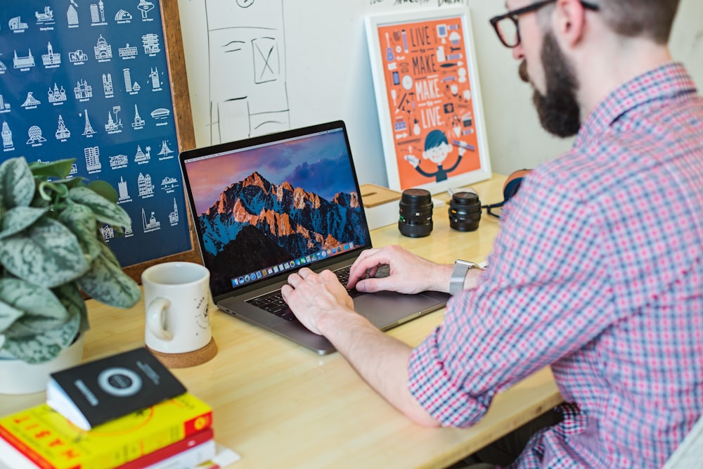 man wearing collared shirt using MacBook