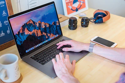 MacBook Pro turned on beside white ceramic mug