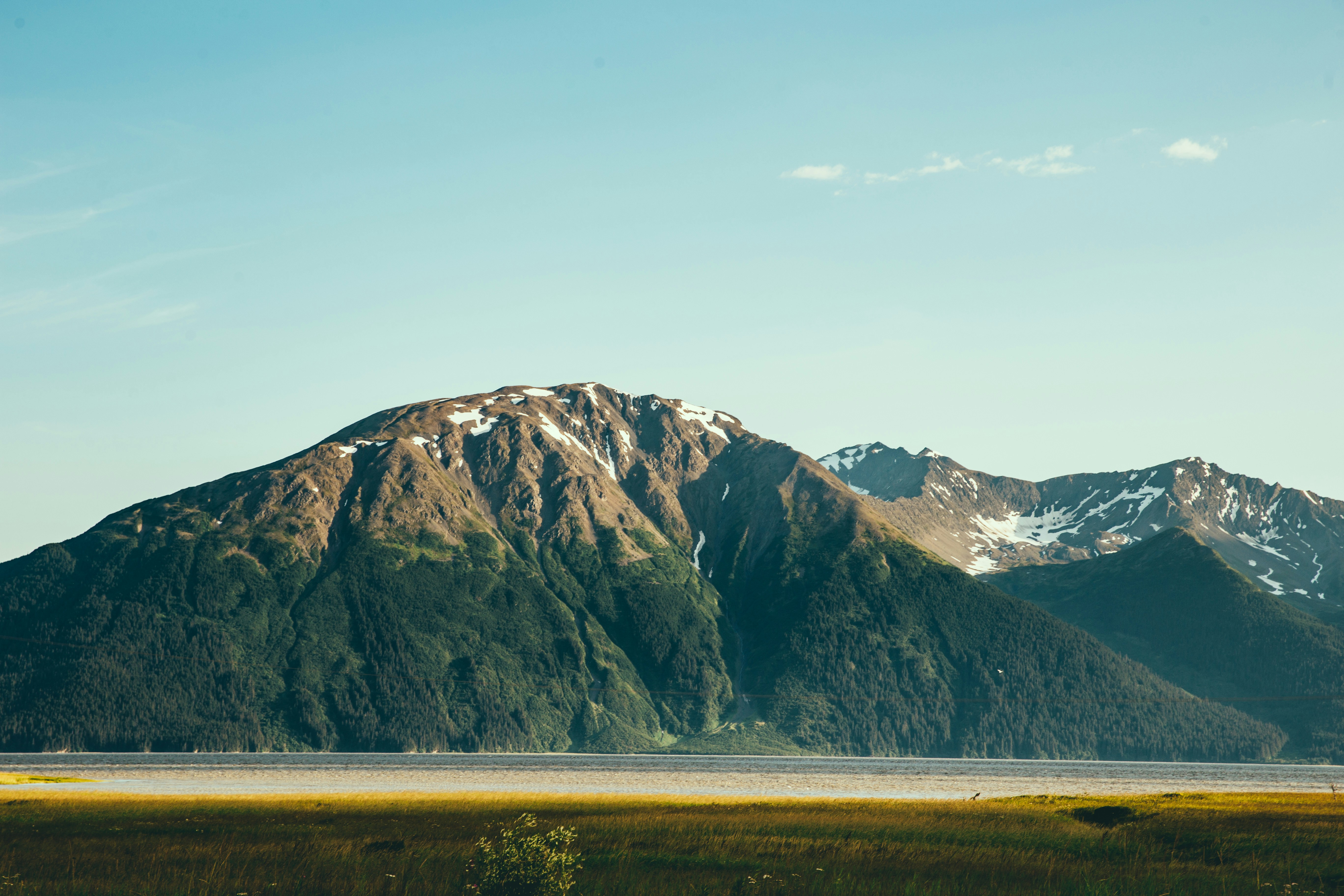 body of water in front of mountain during daytime, 