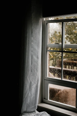 Close-up of a sleek modern window frame with raindrops on the glass.