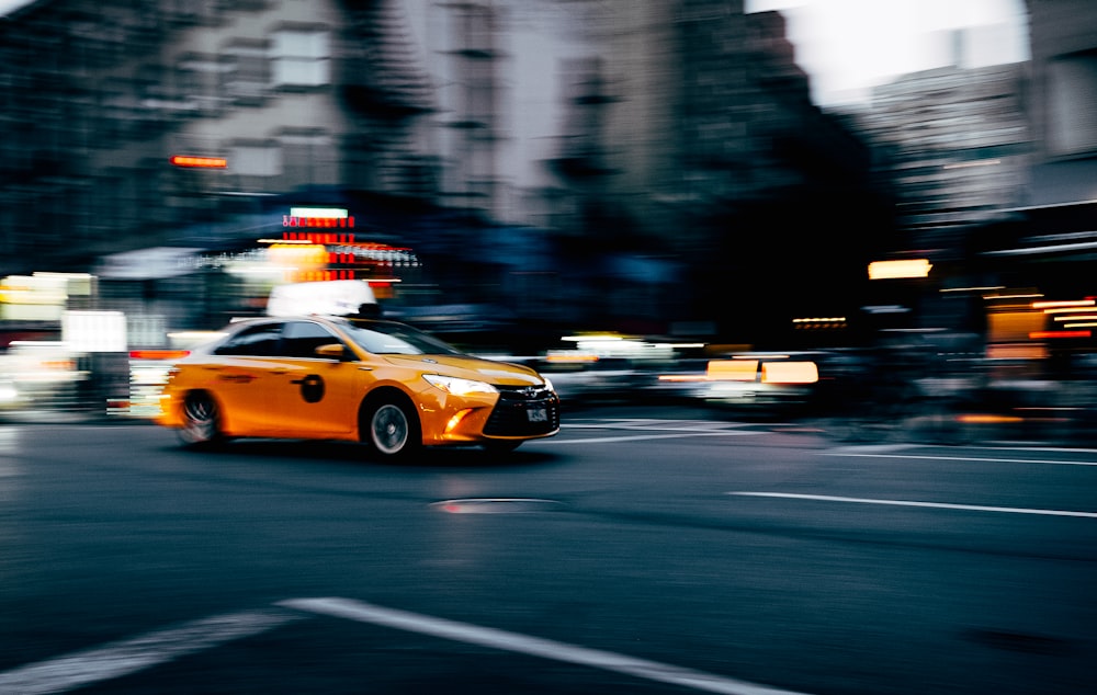 orange coupe running on gray street during daytiem