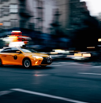 orange coupe running on gray street during daytiem