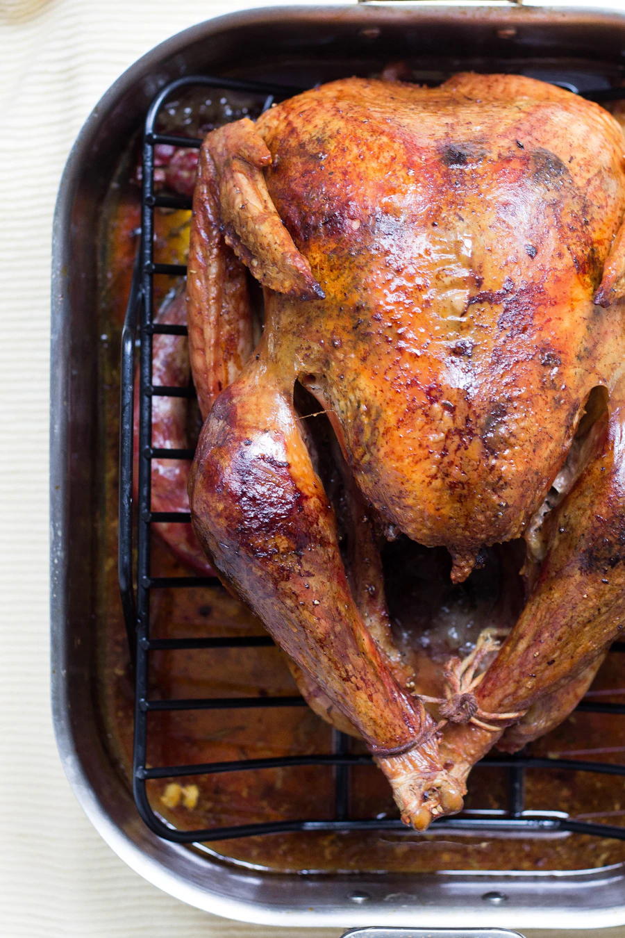 A whole roast chicken in a roasting pan