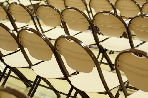 Close-up of spotless white chairs lined up neatly for an event.