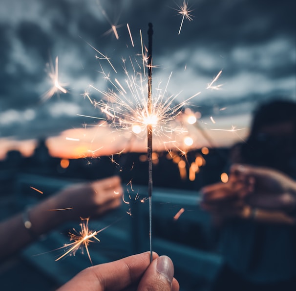 photo of person holding lighted AI sparkler