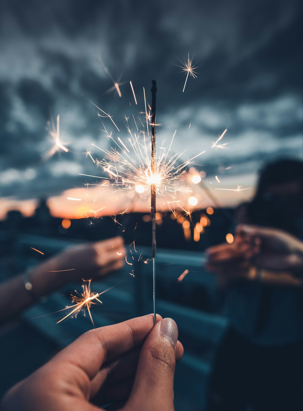 photo of person holding lighted sparkler