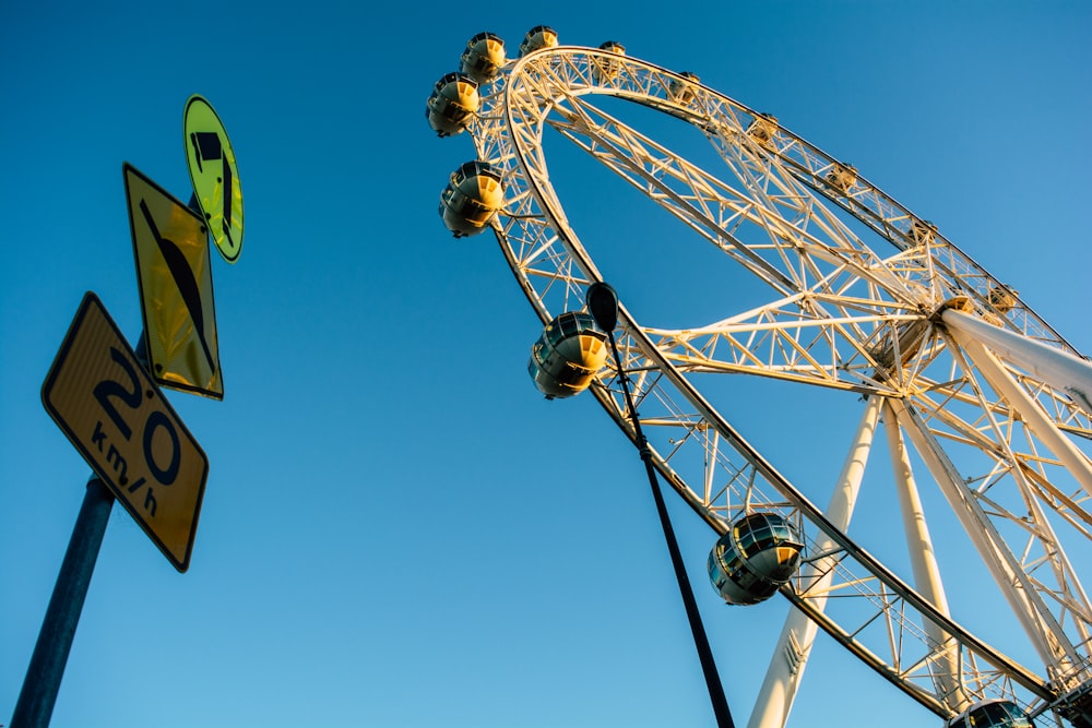 low angle photography of ferris wheel under blue sky during daytime