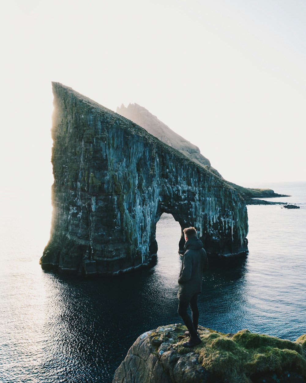 person standing on rock with rock formation background