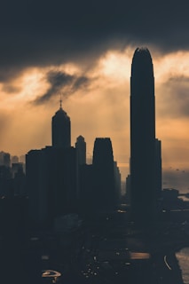 A cinematic still showing a dramatic sunset over a city skyline, highlighting warm golden tones.