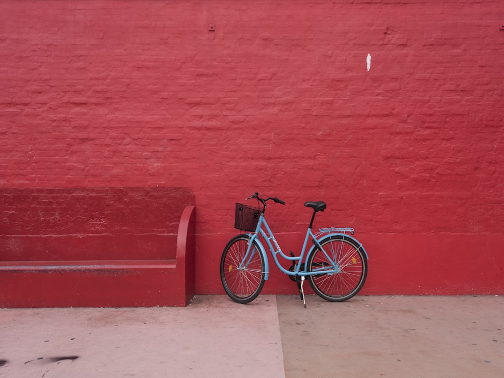 赤いベンチの横の青いステップスルー自転車場