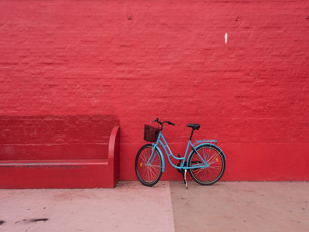 blue step-through bicycle park beside of red bench