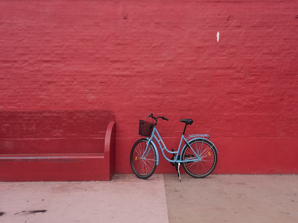 blue step-through bicycle park beside of red bench