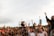 A lively outdoor concert scene with families enjoying music under a clear blue sky.