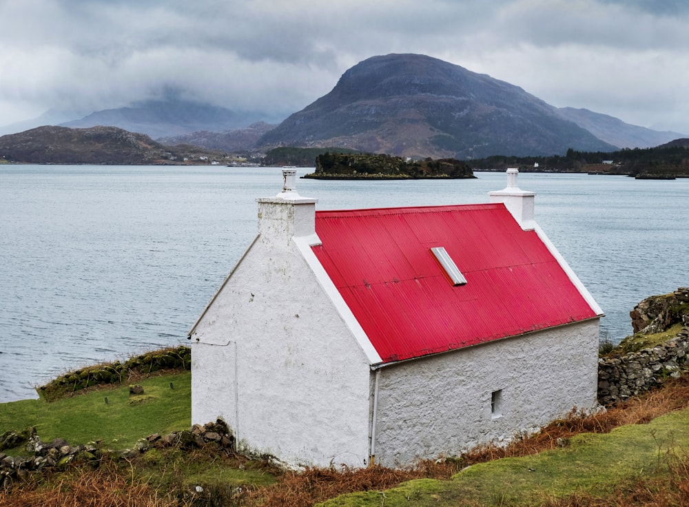 white and red concrete building near body of water during daytime