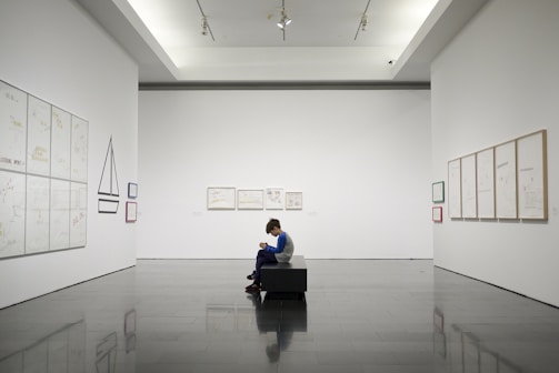 man sitting near museum painting