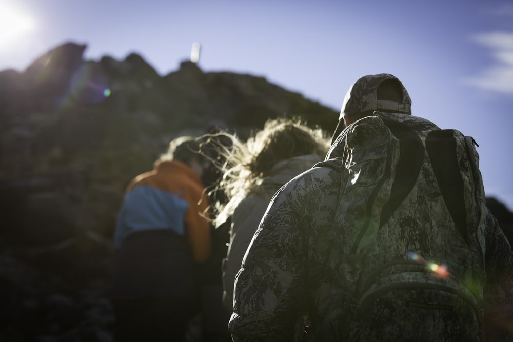 four person standing on top of mountain during daytime