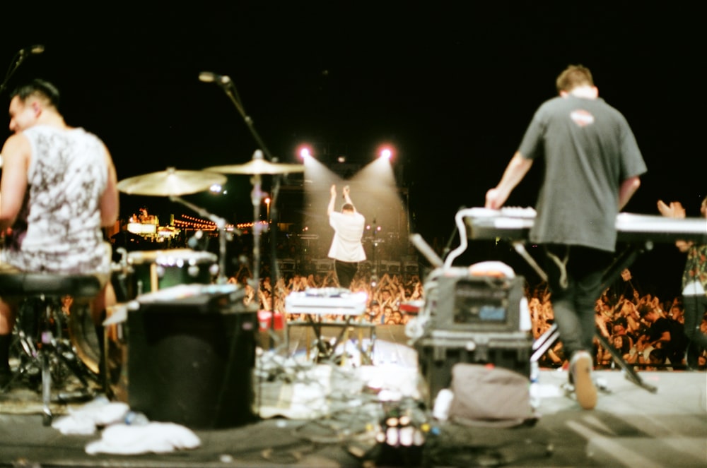 man in black t-shirt standing while playing black electronic keyboard during daytime