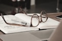 eyeglasses with gray frames on the top of notebook