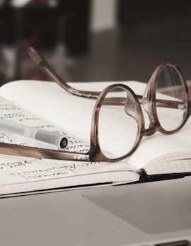 eyeglasses with gray frames on the top of notebook