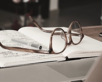 eyeglasses with gray frames on the top of notebook